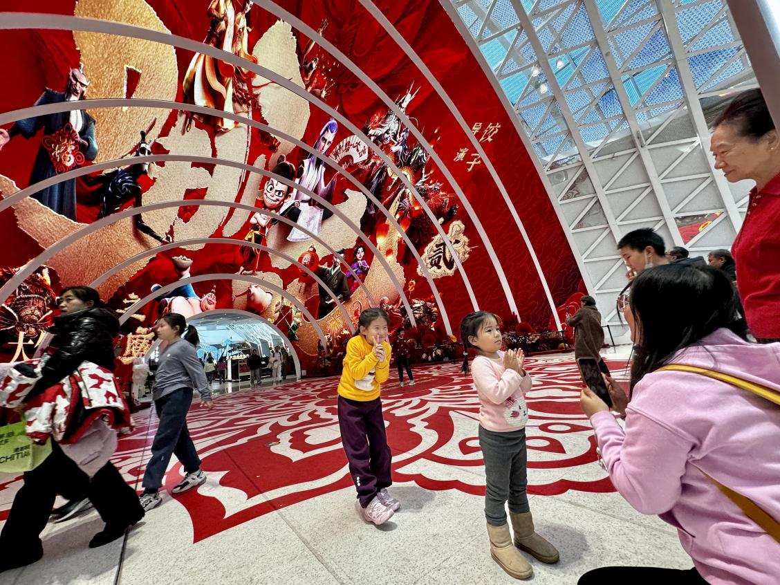 乙巳蛇年春節(jié)期間，影迷在《哪吒之魔童鬧海》巨幅海報前拍照打卡。