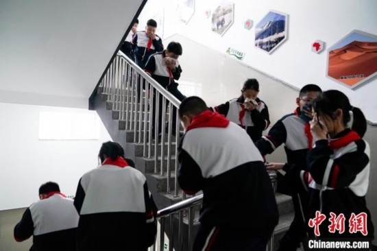  圖為學(xué)生們進(jìn)行應(yīng)急疏散演練。中新社記者 趙宇航 攝