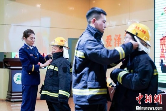 圖為學(xué)生們現(xiàn)場(chǎng)穿戴消防頭盔和戰(zhàn)斗服。中新社記者 趙宇航 攝