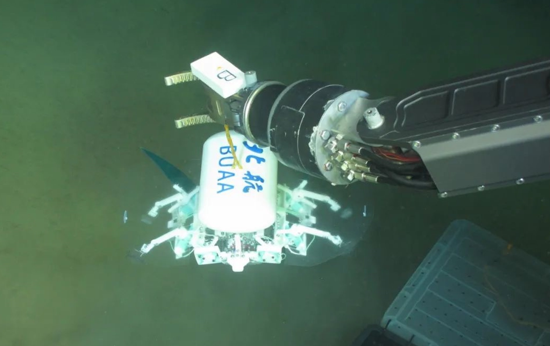 科研人員利用機(jī)械臂將北航深海小型機(jī)器人投于馬里亞納海溝。校方供圖