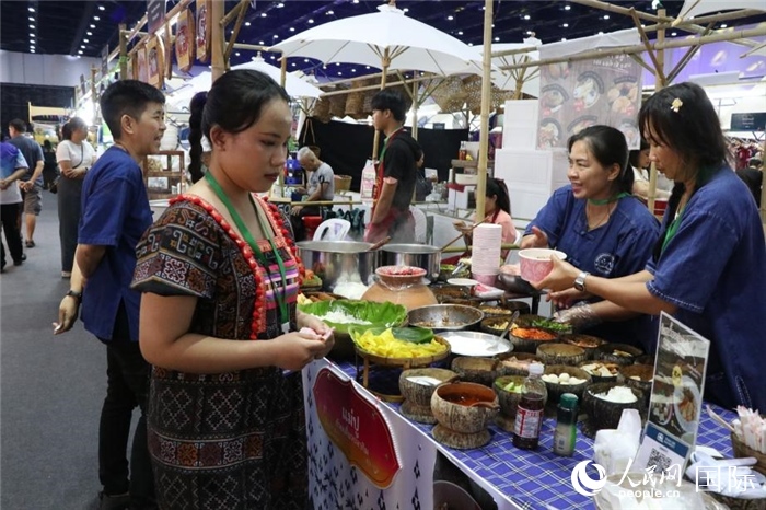 游客在攤位前購買特色美食。朱瀟逸攝