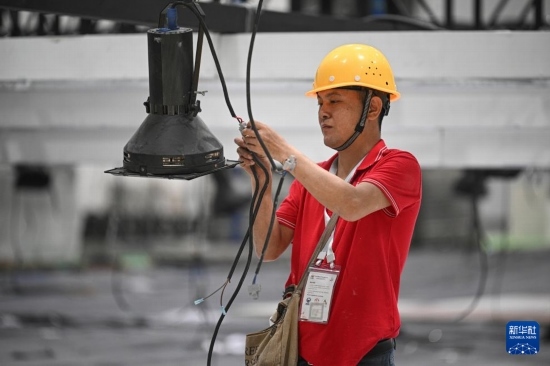 4月4日，工作人員在海南國(guó)際會(huì)展中心內(nèi)布設(shè)燈光。