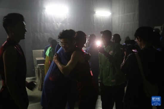 4月10日，在塞內加爾首都達喀爾的國家大劇院，中央音樂學院進擊打擊樂團成員與塞內加爾杜杜·恩迪亞耶·羅斯打擊樂團成員在演出后臺擁抱。新華社記者 司源 攝