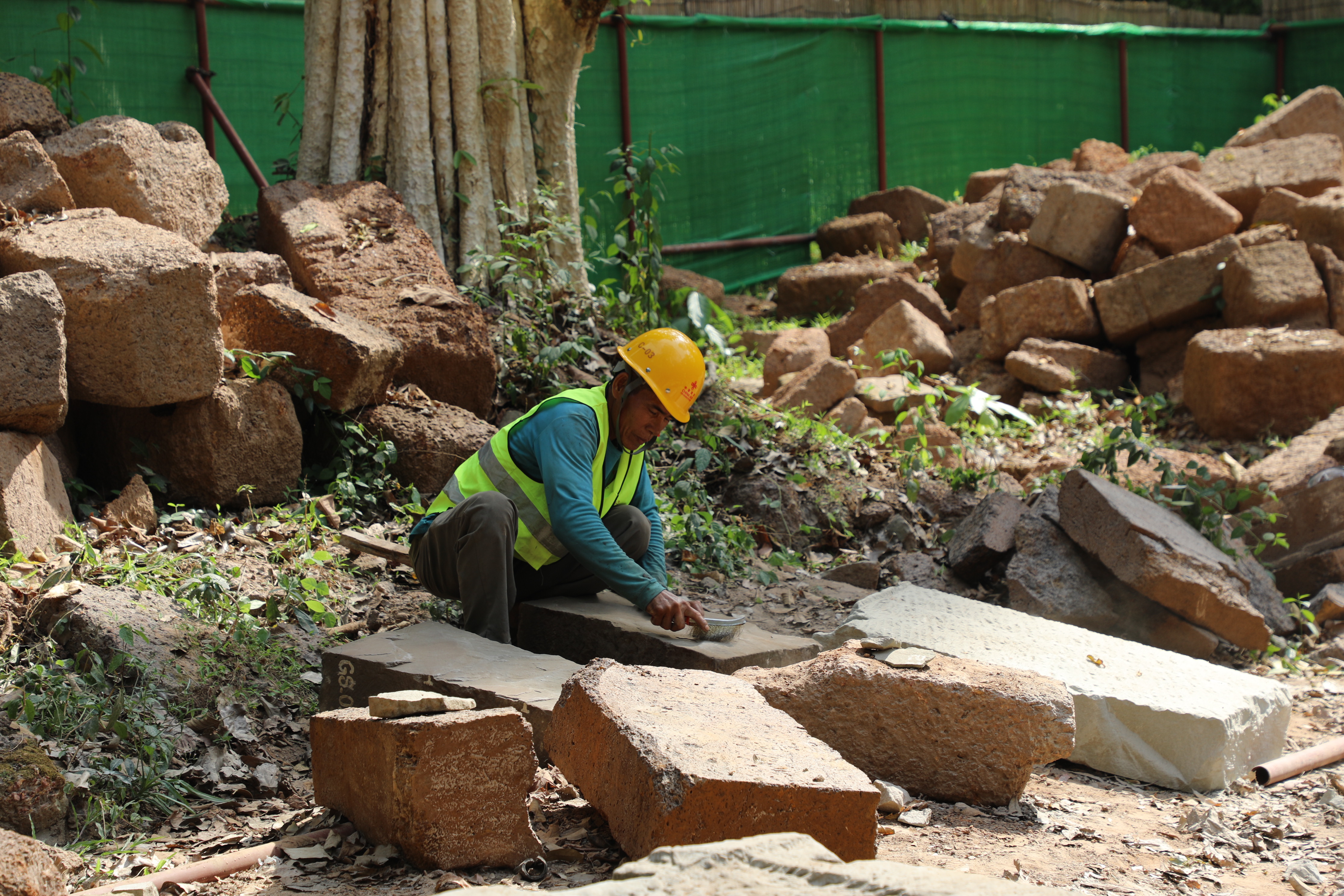 一名柬埔寨工人正在王宮遺址修復(fù)現(xiàn)場(chǎng)工作。（人民日?qǐng)?bào)記者曹師韻 攝）