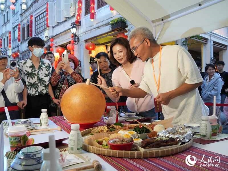 嘉賓品嘗海南傳統(tǒng)美食“煎堆”。人民網(wǎng)記者 張力洋攝
