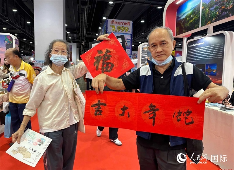 2025蛇年春節(jié)，泰國市民展示他們領(lǐng)到的華人手寫春聯(lián)。人民網(wǎng)記者 簡承淵攝