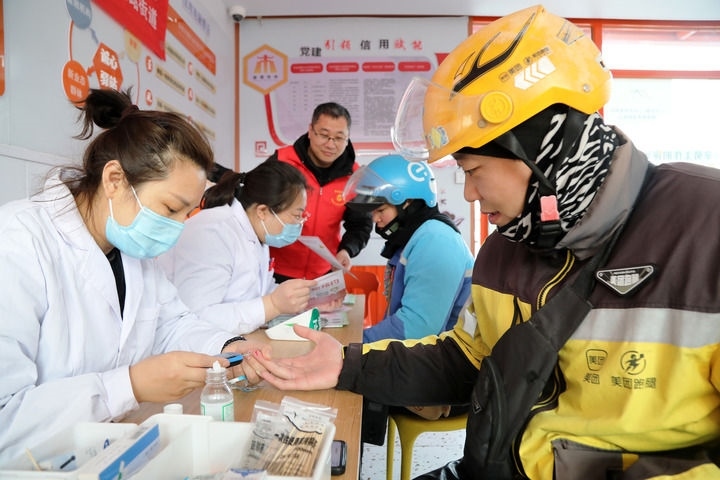 2025年3月5日，志愿者在山東省棗莊市市中區(qū)一工會驛站為外賣員免費測量血糖。新華社發(fā)（王海楠攝）