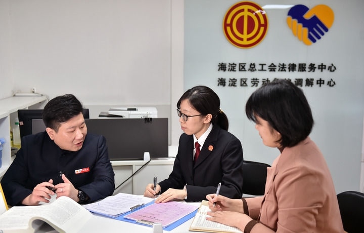2025年3月6日，在北京市海淀區(qū)總工會勞動爭議調(diào)解中心，海淀區(qū)人民法院法官王琰（中）與該中心工作人員就糾紛化解情況進(jìn)行溝通。新華社記者 趙婷婷 攝