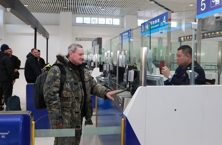 2024年12月10日，在黑河公路口岸旅檢大廳，黑河出入境邊防檢查站民警為首班次客車入境旅客辦理邊檢通關(guān)手續(xù)。當日，中國黑河公路口岸—俄羅斯卡尼庫爾干公路口岸旅客運輸正式開通。新華社發(fā)（劉松攝）