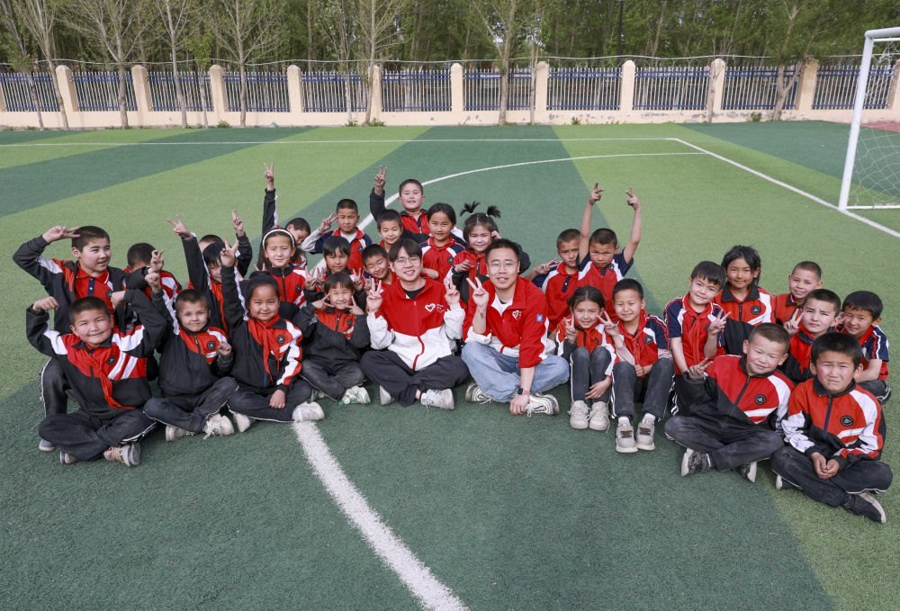4月23日，在新疆克州阿圖什市哈拉峻鄉(xiāng)謝依特小學(xué)，支教教師王俊文（中左）、李軻凡（中右）和學(xué)生在一起。