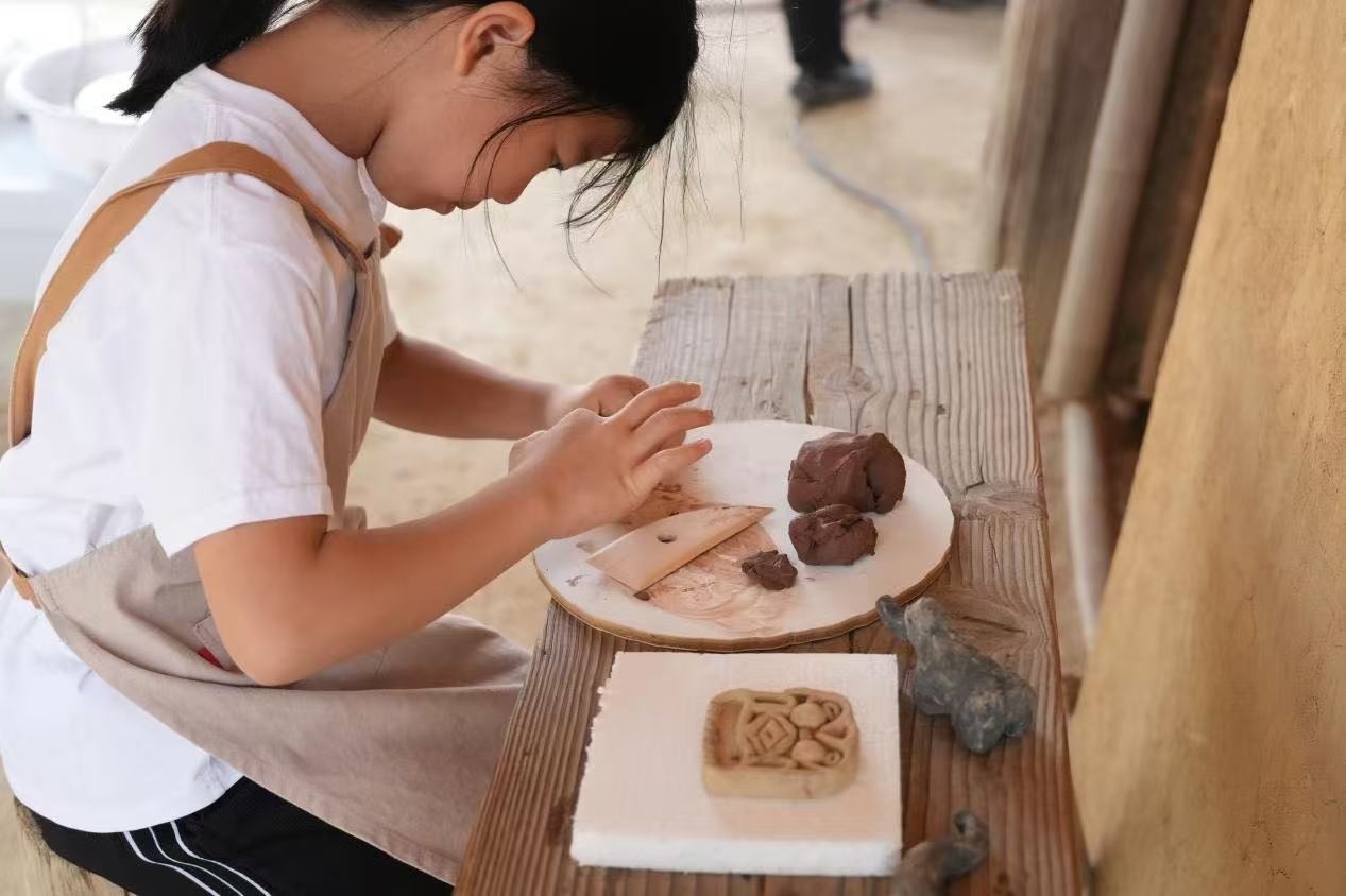 游客制作良渚特色陶藝品。良渚博物院供圖