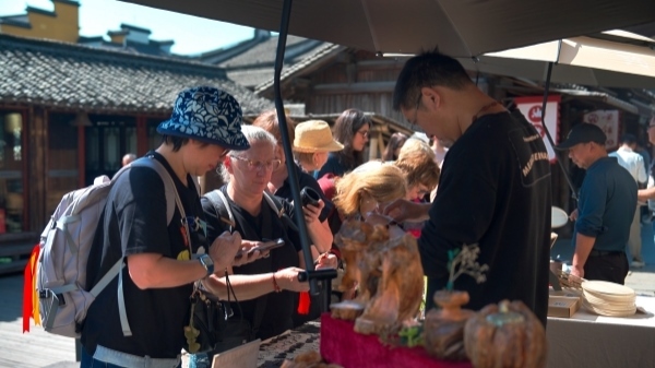 “五一”期間，游客正在烏鎮(zhèn)“水鄉(xiāng)碼頭”挑選購(gòu)買文創(chuàng)產(chǎn)品。受訪者供圖