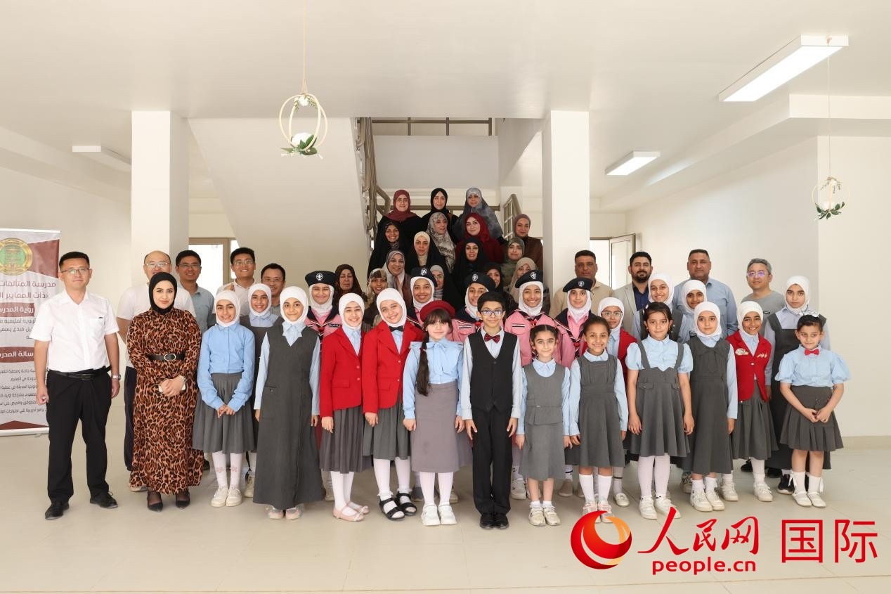 中國電建員工與阿爾穆塔?阿里卡特國際學校的師生及政府官員等合影。人民網記者 薛丹攝