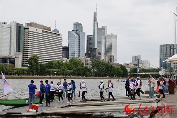 來自美國的快樂龍舟隊(duì)選手們正在登船準(zhǔn)備參賽。人民網(wǎng)記者 劉仲華攝