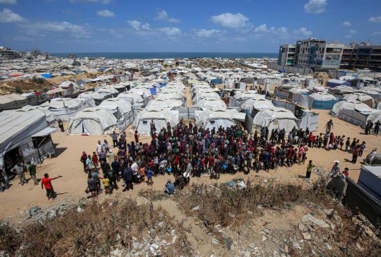 5月28日，人們在加沙城西部的沙提難民營等待領(lǐng)取救助食物。新華社發(fā)（里澤克·阿卜杜勒賈瓦德攝）