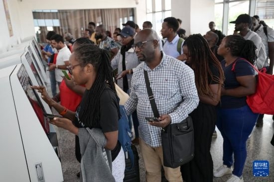 5月31日，在蒙內(nèi)鐵路內(nèi)羅畢站，乘客在自助取票機(jī)前排隊(duì)取票。新華社記者 楊光 攝