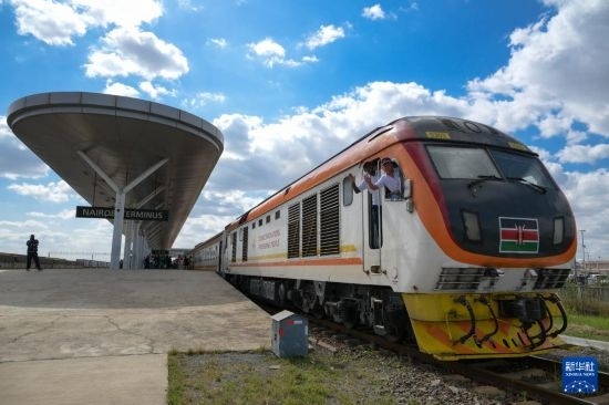 5月31日，在蒙內(nèi)鐵路內(nèi)羅畢站，機(jī)車駕駛員蔣立平（右）和博爾在即將開往蒙巴薩的E2次列車上揮手致意。新華社記者 楊光 攝