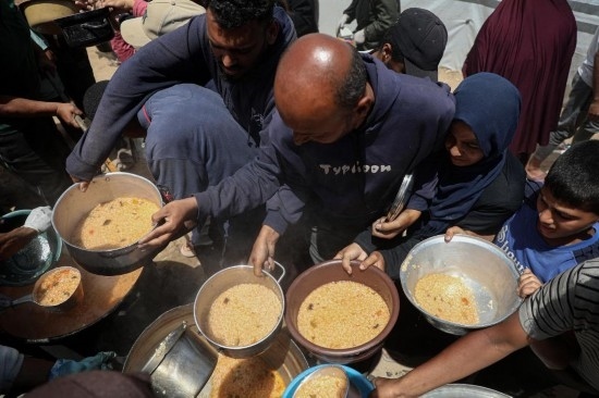 5月28日，人們在加沙城西部的沙提難民營領(lǐng)取救助食物。新華社發(fā)（里澤克·阿卜杜勒賈瓦德攝）