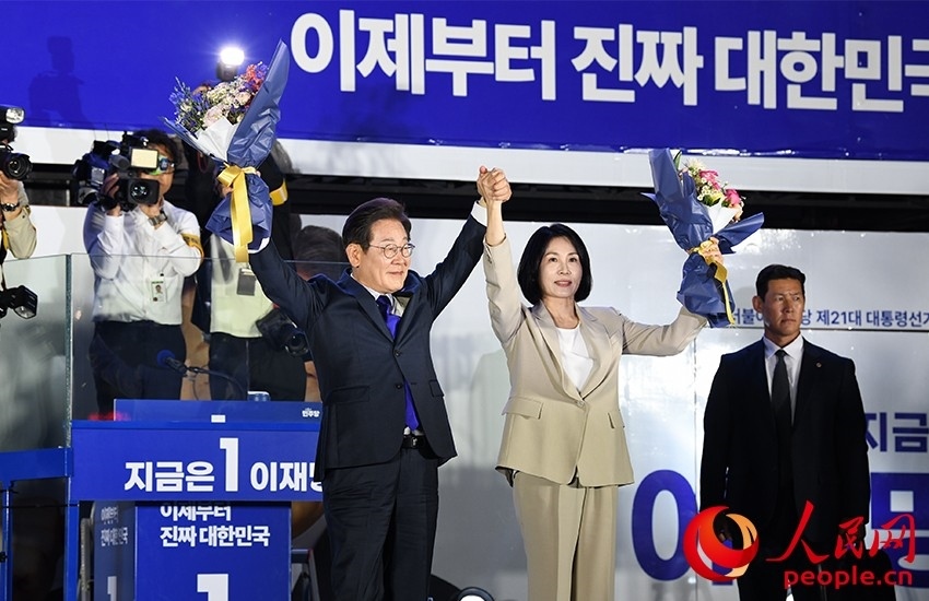 6月4日凌晨，確定當(dāng)選韓國總統(tǒng)的李在明舉手向歡呼的支持者們致意。 人民網(wǎng) 康炯彬攝